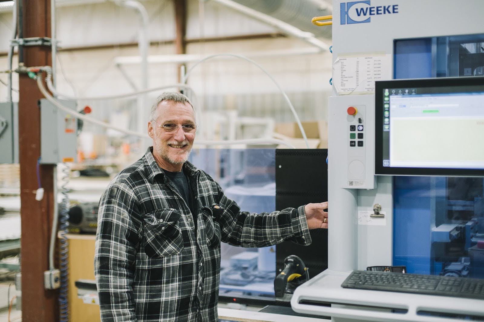 A smiling man standing beside a piece of machinery