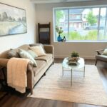A cozy living room with a large picture window, a coffee table and chair
