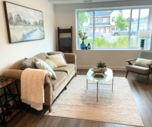 A cozy living room with a large picture window, a coffee table and chair